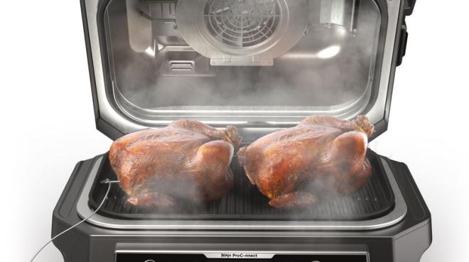 Auf dem Ninja Woodfire Pro Connect XL Outdoor Grill & Smoker OG901 können problemlos zwei Hähnchen gleichzeitig zubereitet werden. Das Thermometer sorgt dabei für den perfekten Gargrad, der mobil angezeigt wird.
